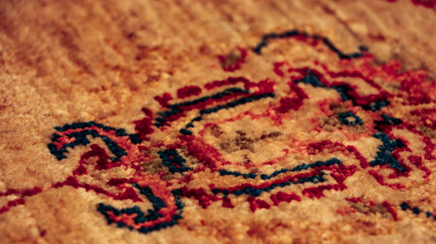 Patrones intrincados de alfombra tejida en rojo y turquesa.