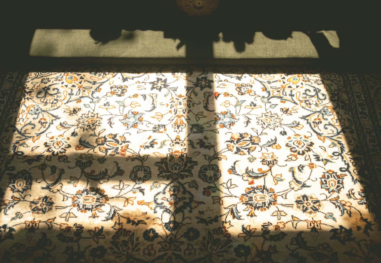 Una alfombra persa estampada sobre un suelo verde oliva.