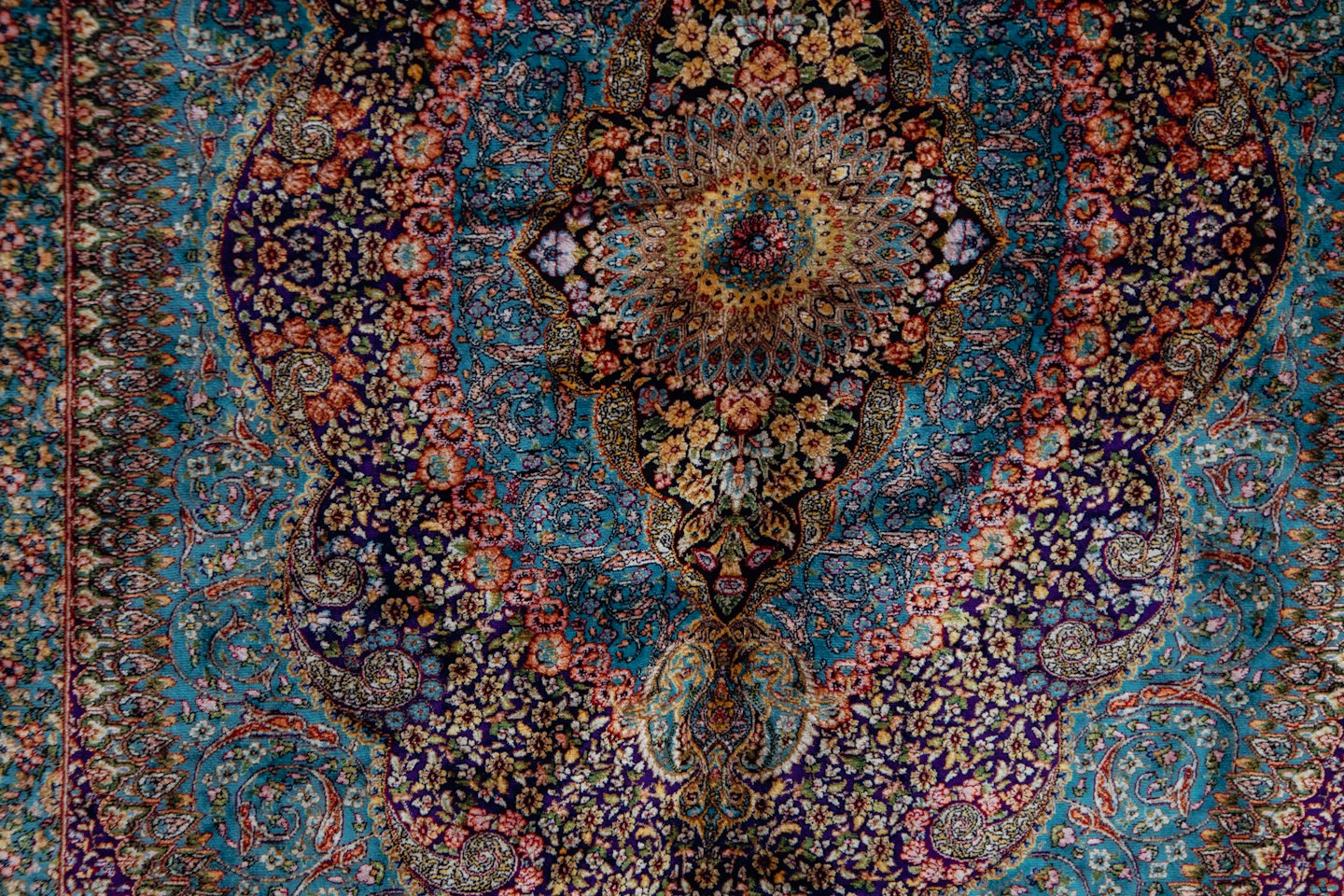 Alfombra persa de intrincado diseño con un medallón floral central.