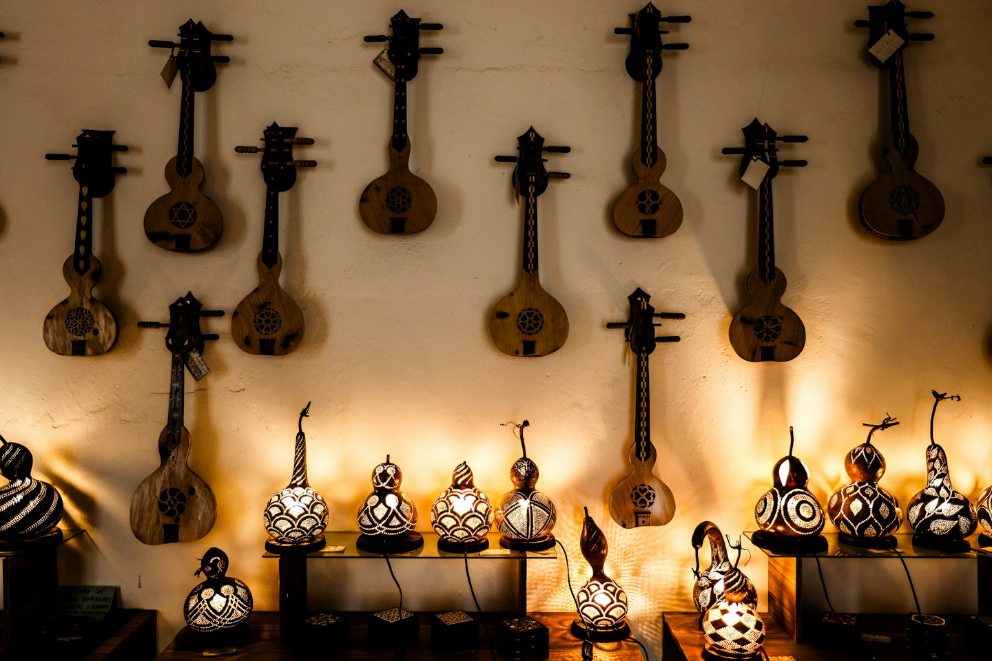 Lámparas de calabaza y instrumentos de cuerda hechos a mano en una tienda.